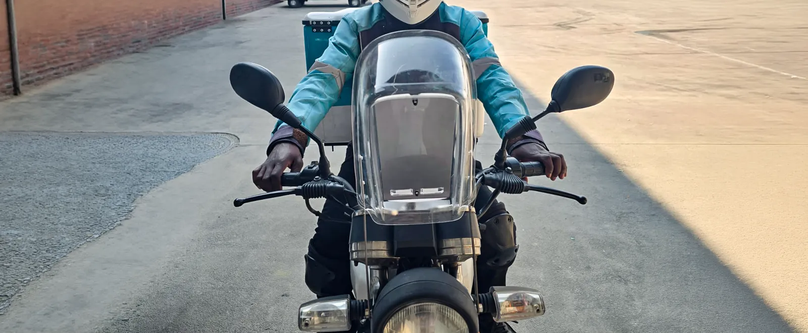 Delivery rider on a motorcycle fitted with the EyesUp navigation dock, viewed from the front